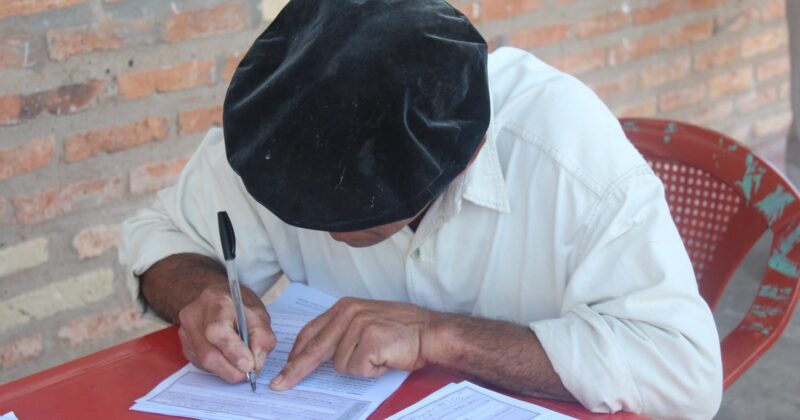 close up photo of man writing on paper with a pen
