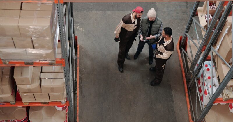 men standing in a warehouse talking